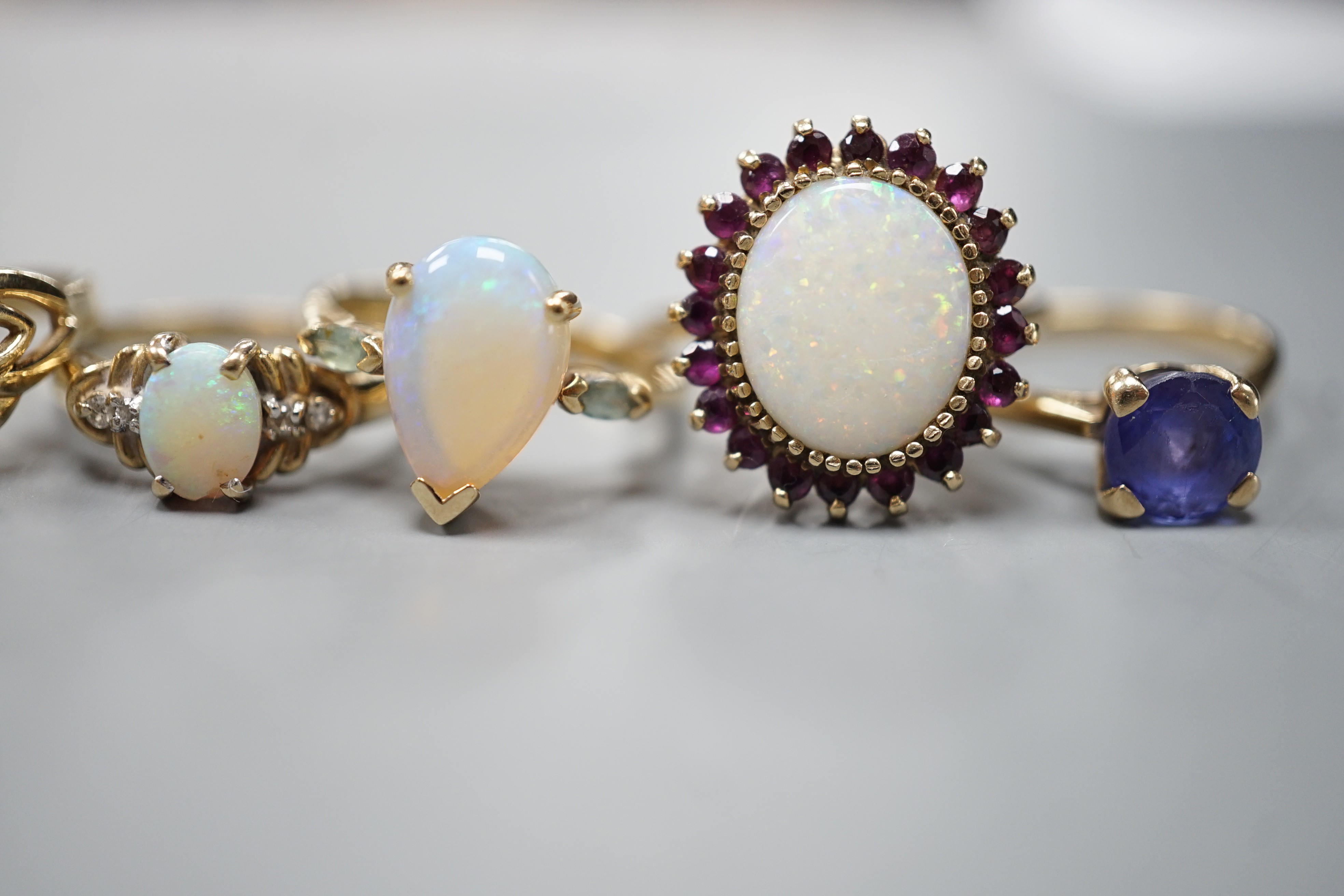 Five assorted modern 9ct gold and gem set dress rings, including white opal and garnet oval cluster, white opal and diamond chip and single stone white opal